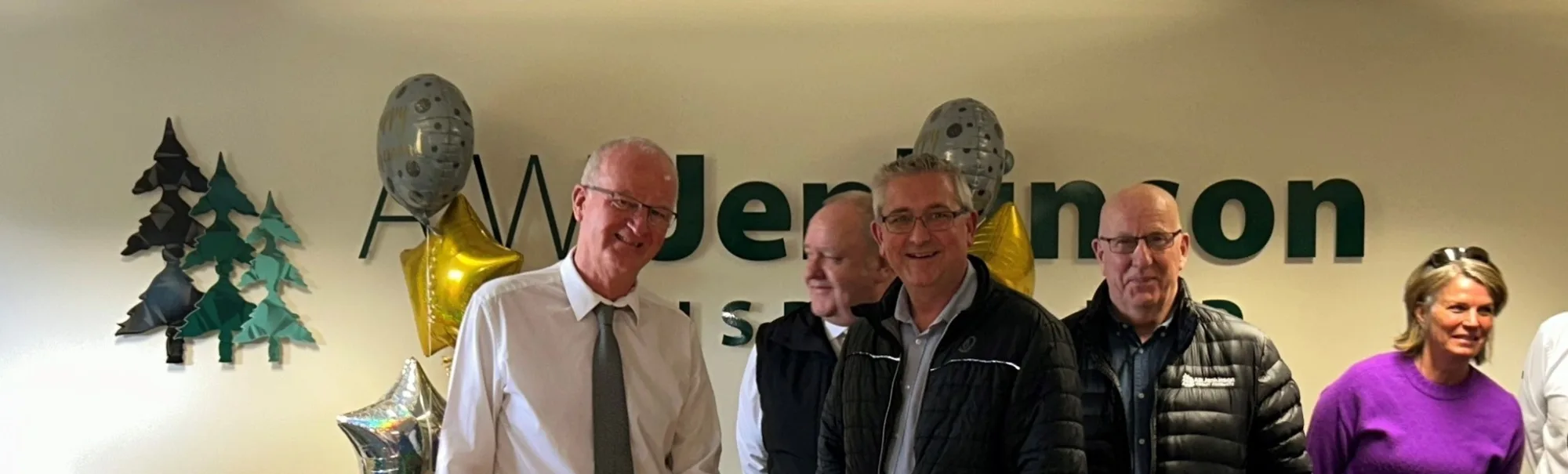 Brian Blenkharn and David Lindop cutting cake with a buffet table in front
