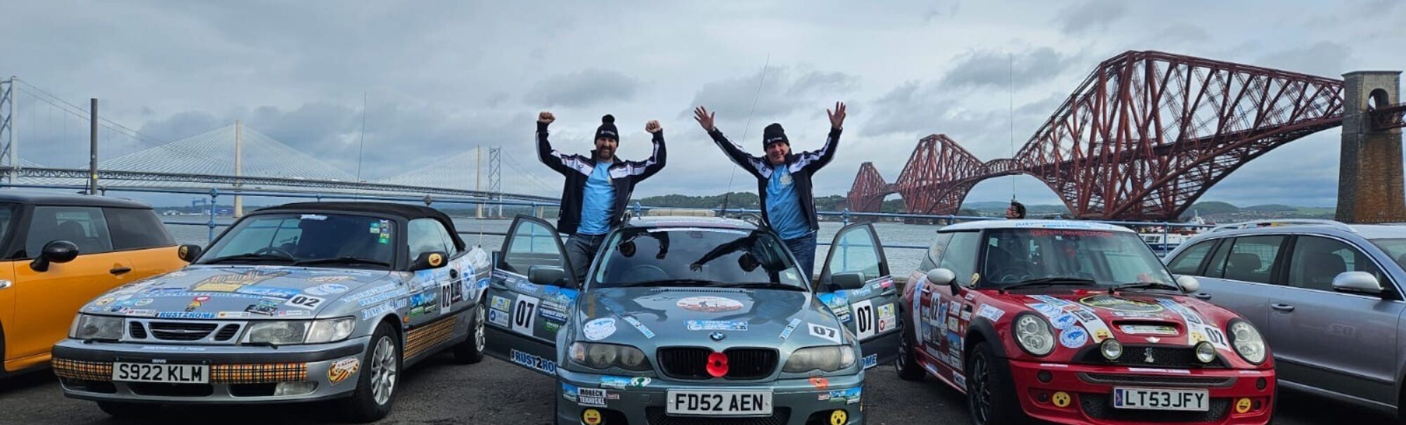 Cars with Dom and Norman standing with their arms in the air celebrating.